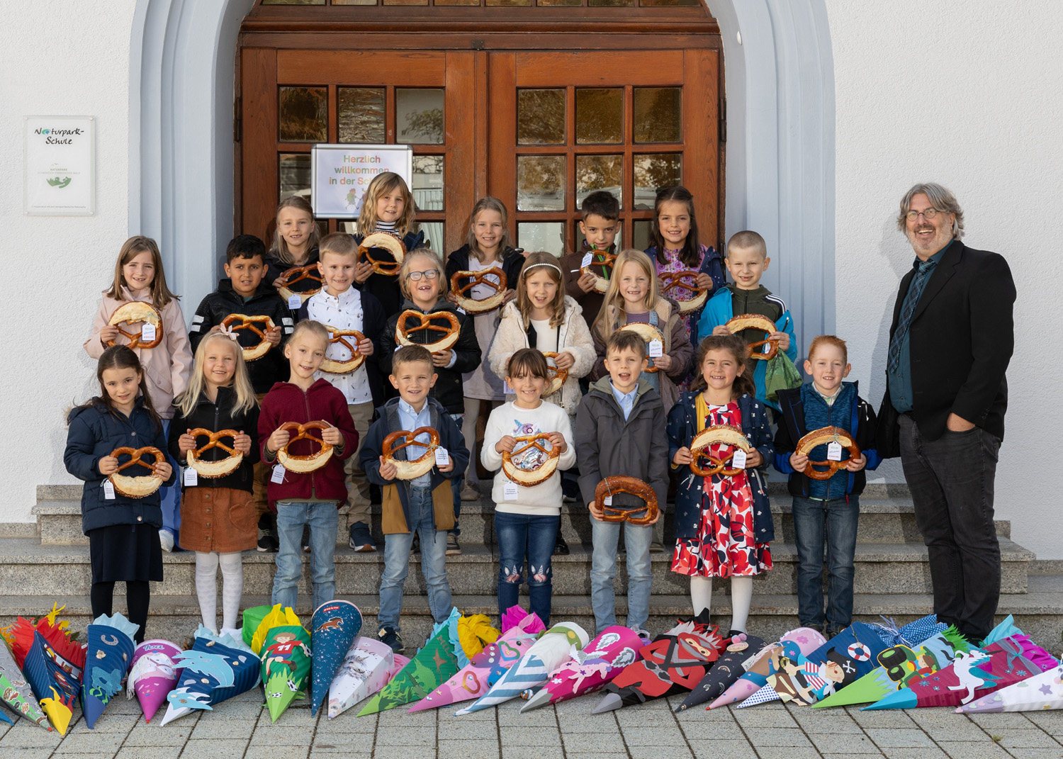 Klassenfoto vom Einschulungstag mit Schultüten und Riesenbrezel