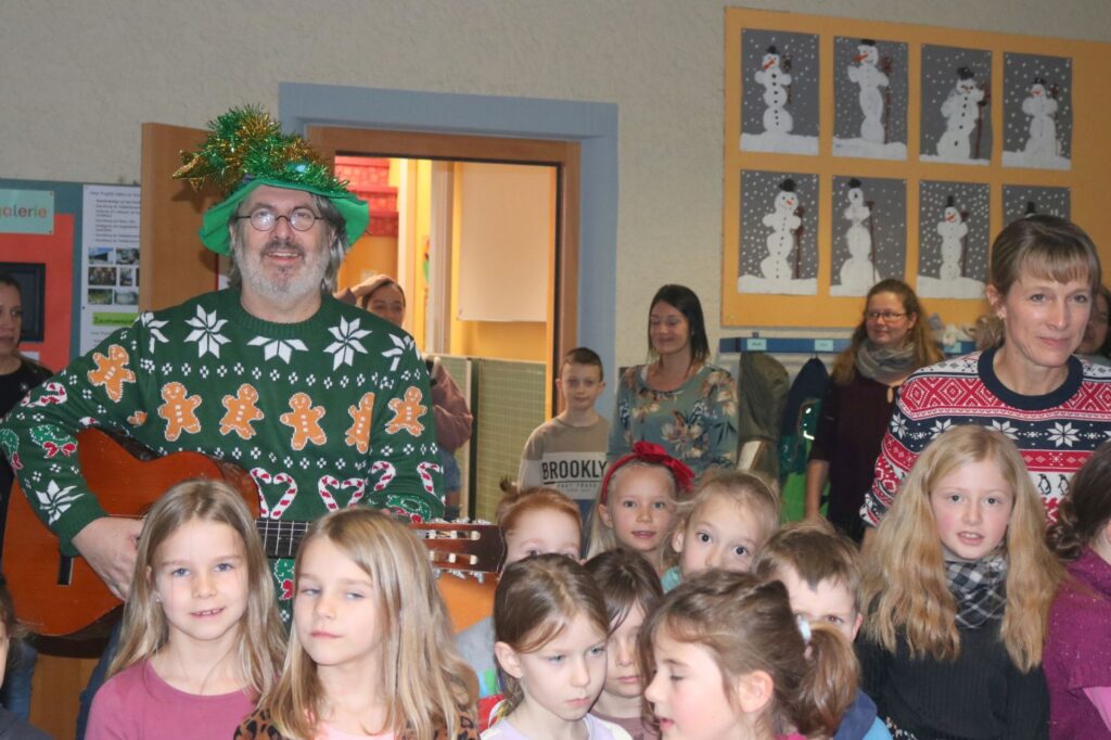 Herr Hieber und viele Kinder zum Abschluss in der Aula.