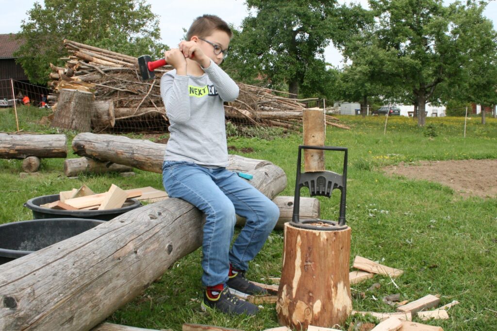Junge beim kindersicheren Holzspalten