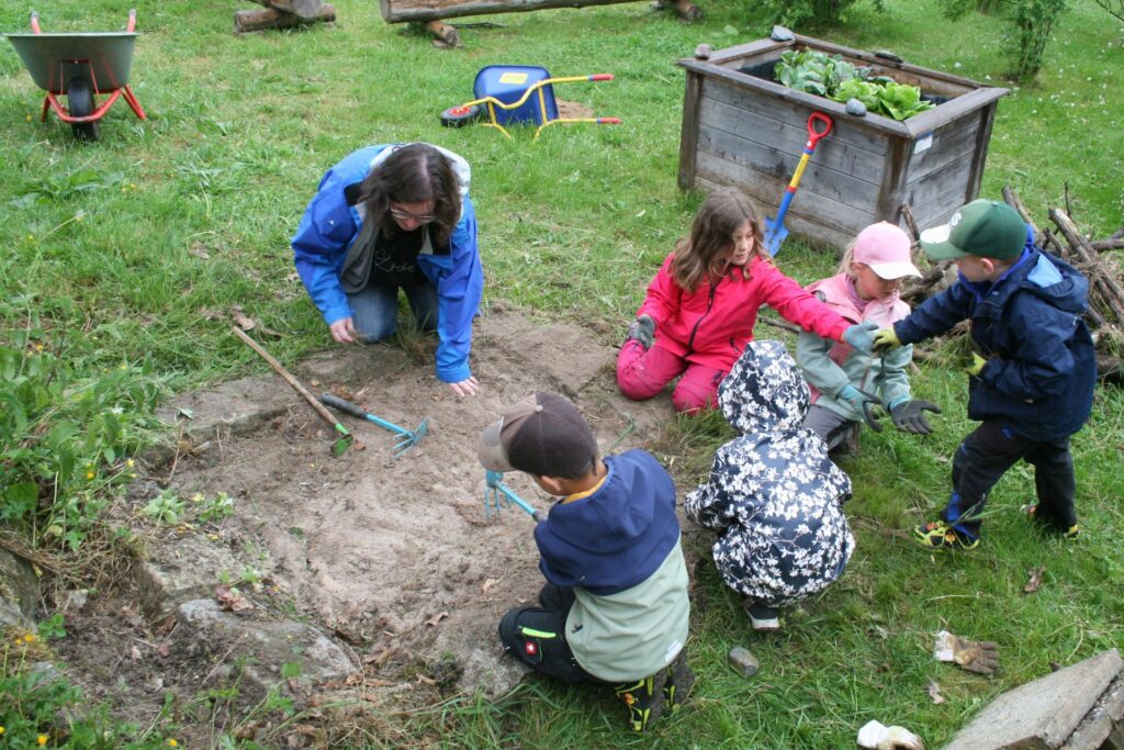 Die Kinder machen den Sand wieder frei von Unkraut