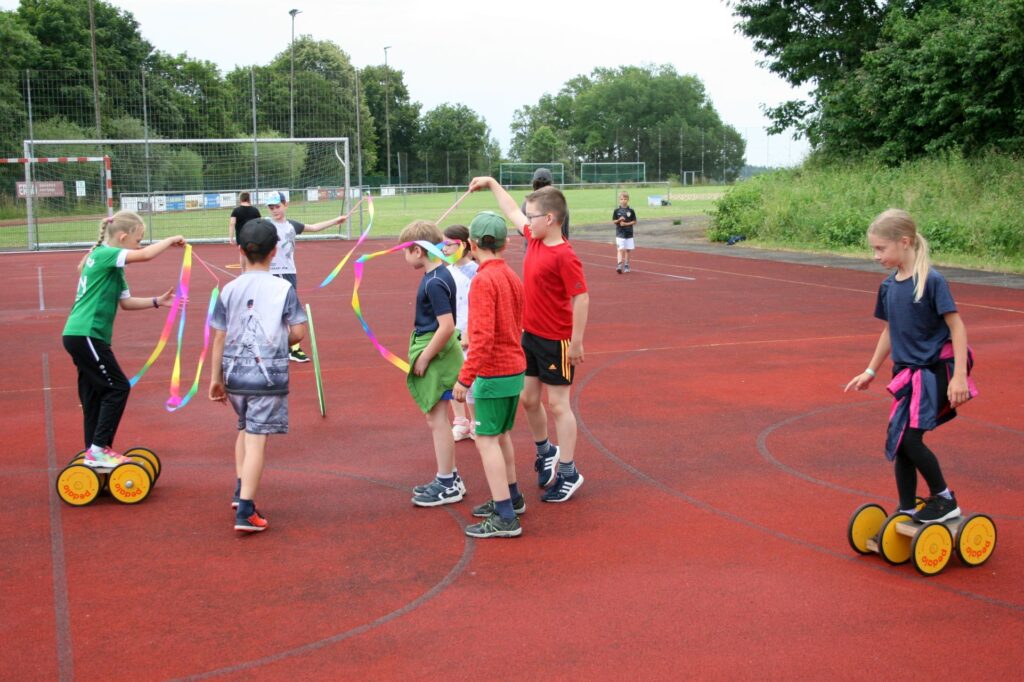 Mehrer Kinder spielen mit Pedalos und Bändern