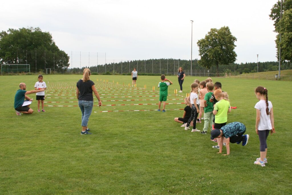 Die Kinder stehen vor dem Zonen- Weitwurf an