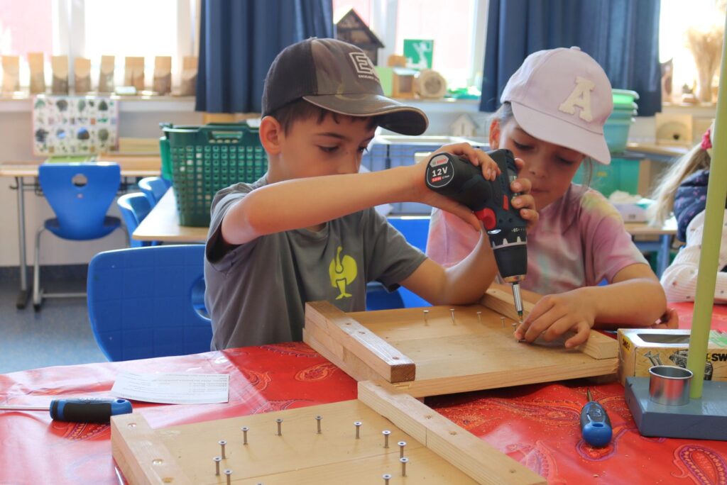 Zwei Kinder aus Klasse 1 mit dem Akkuschrauber
