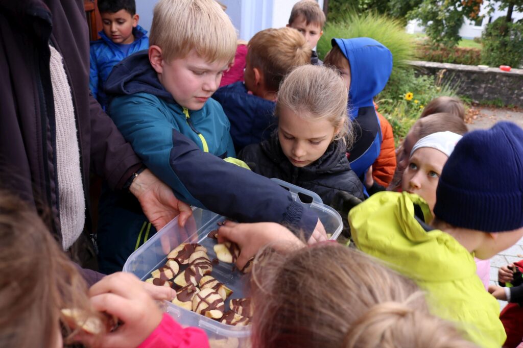 Die Kinder scharen sich um das Tablett mit den leckeren Schokoäpfeln