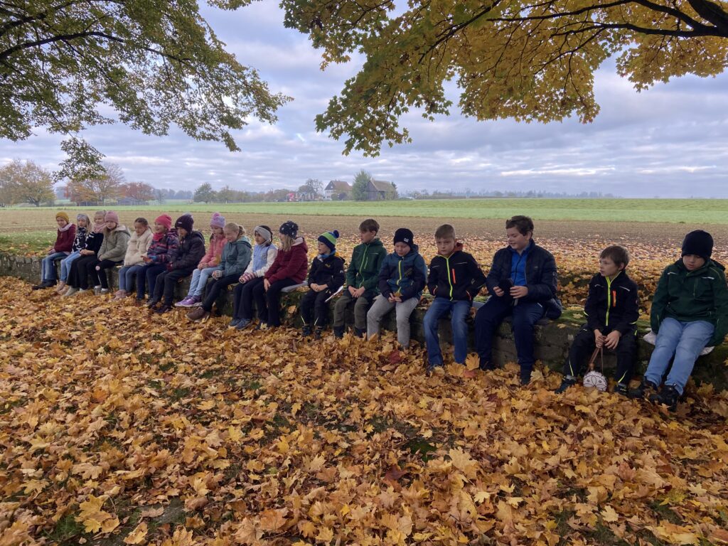 Alle Kinder sitzen auf einer Restmauer des Kleinkastells