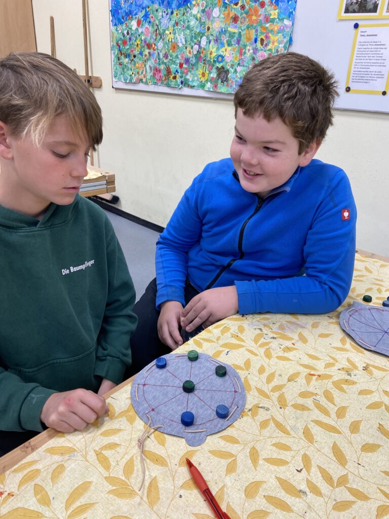 Zwei Jungs spielen das Rundmühlespiel