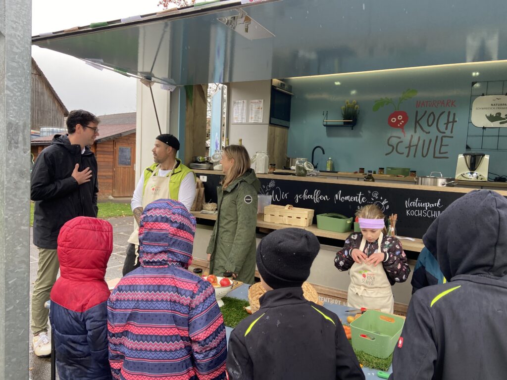 MdL Ralf Nentwich mit den Kindern und Koch vor dem Kochbus.
