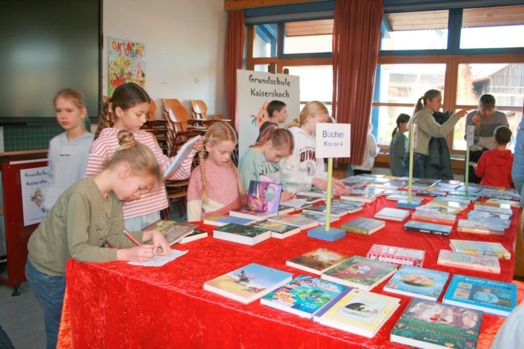 Viele Kinder schauen sich die Bücher im Musiksaal an.