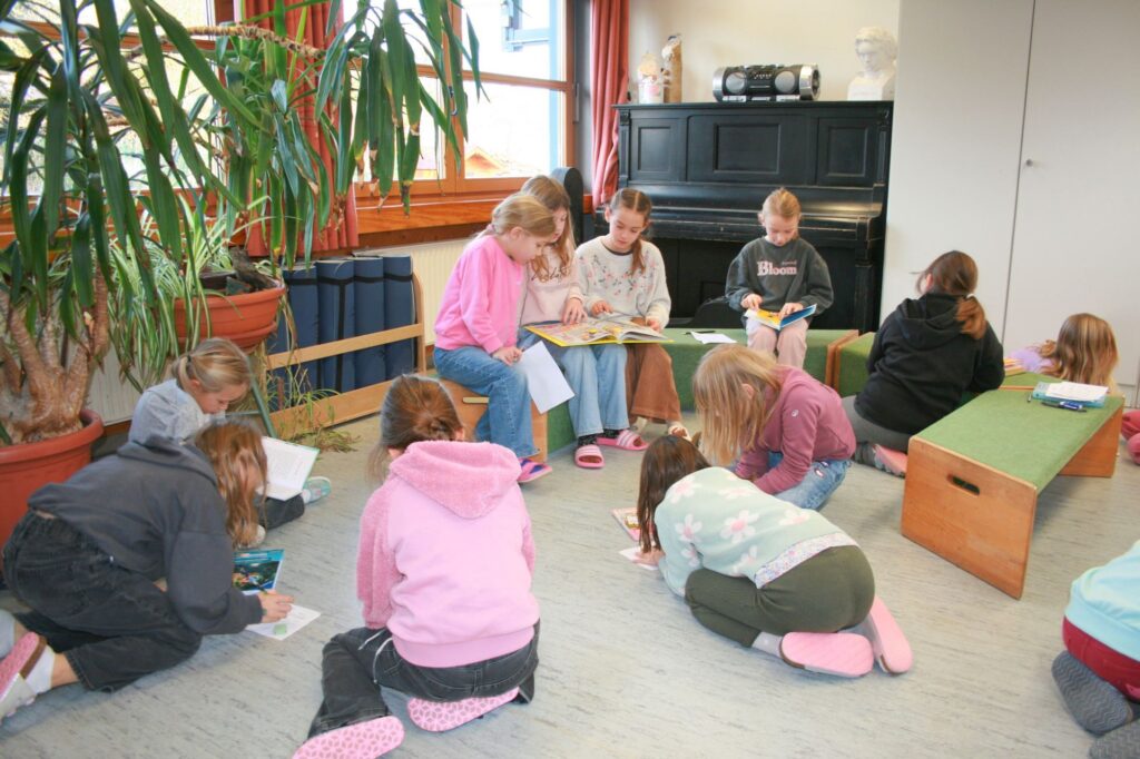 Auf den Sitzpodesten schmökern viele Kinder in den Büchern.
