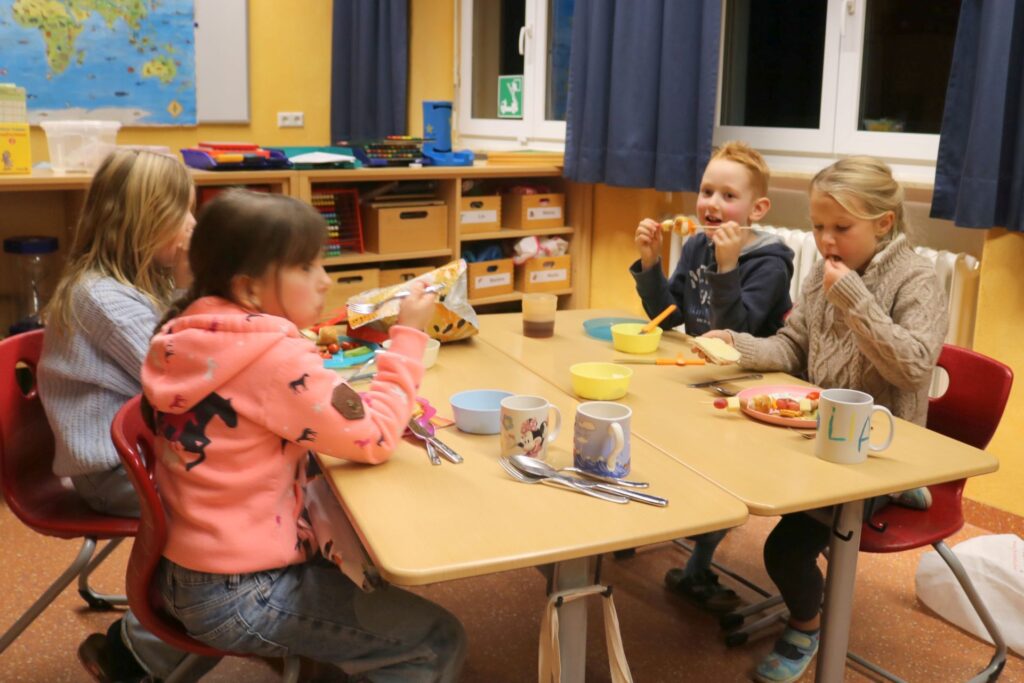 Vier Kinder am Gruppentisch lassen es sich schmecken.