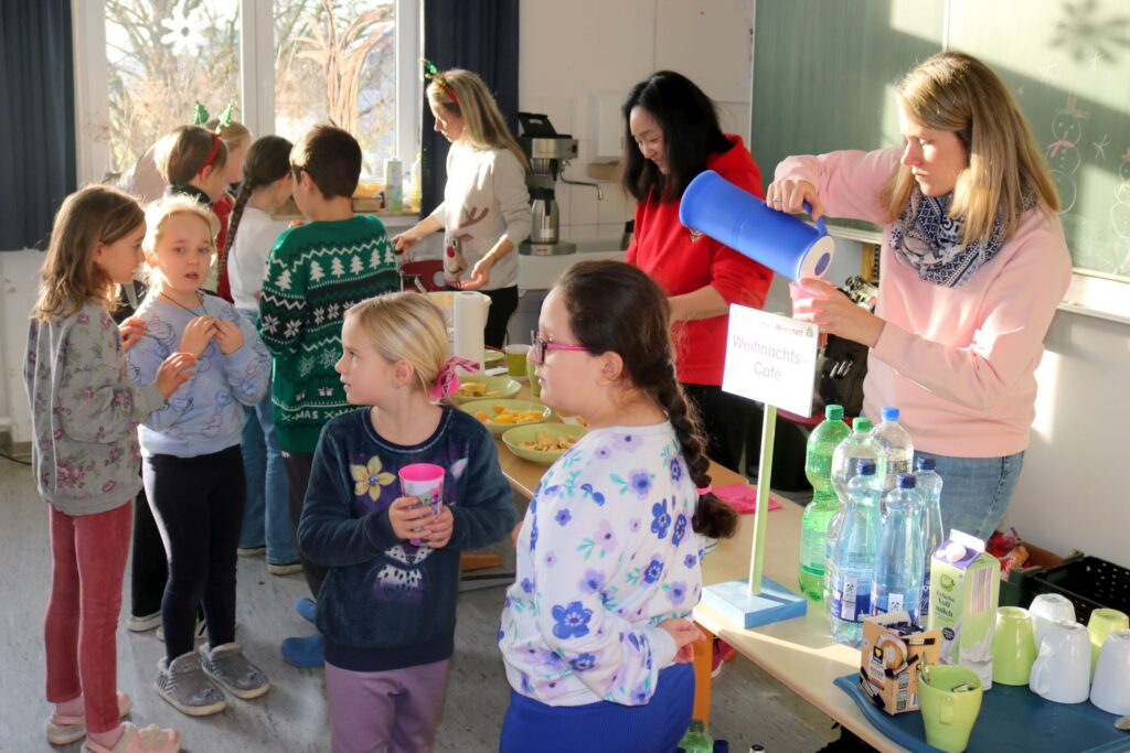 Viele Kinder stehen an, um sich im Weihnachtscafé eine frische Waffel zu holen.