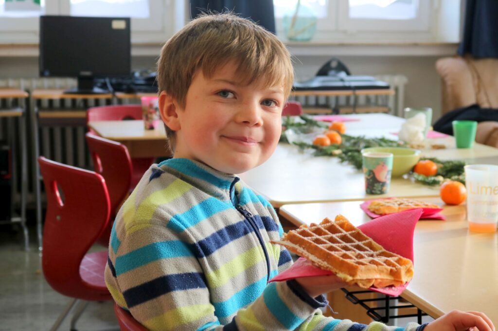Ein Junge mit seiner leckeren Waffel.