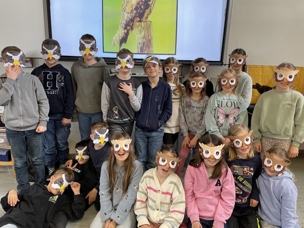 Klassenfoto mit selbstgebastelten Eulen- und Habicht- Masken