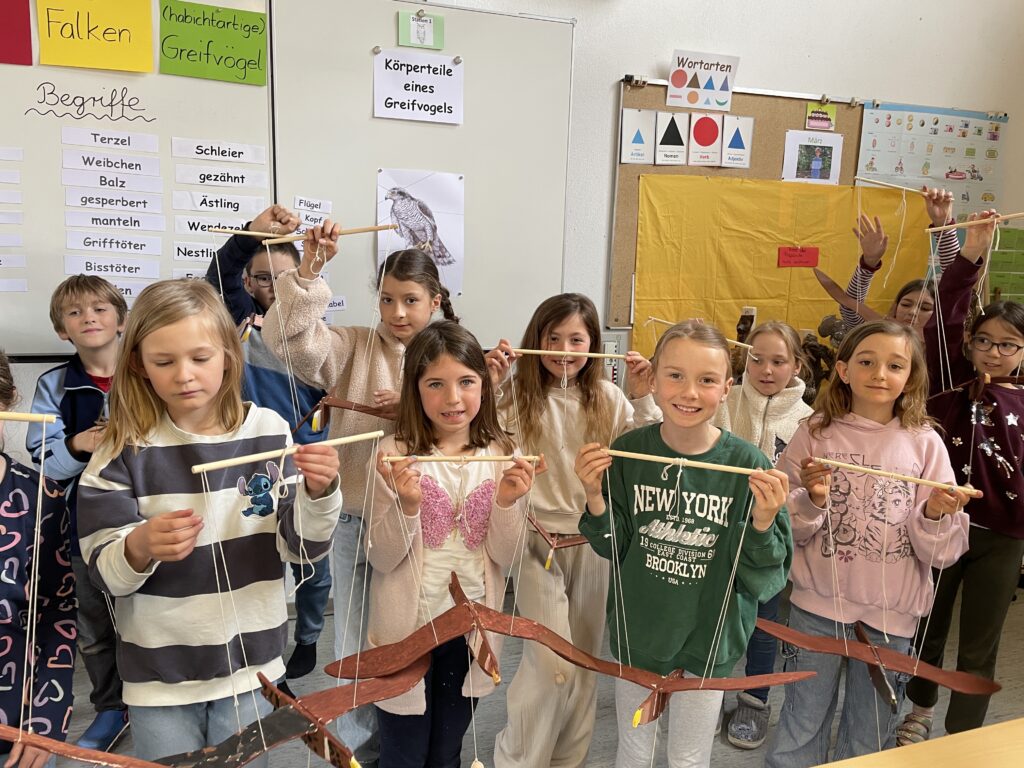 Die Kinder mit ihren Greifvogelmobiles, die sie selbst ausgesägt hatten.