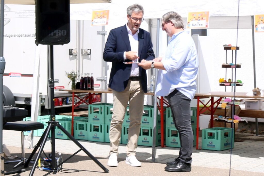 Bürgermeister Michael Clauss überreicht Herrn Hieber eine Spende für den Hühnerstall